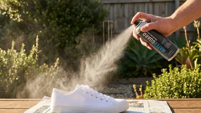 スニーカーに防水スプレーをかけている様子