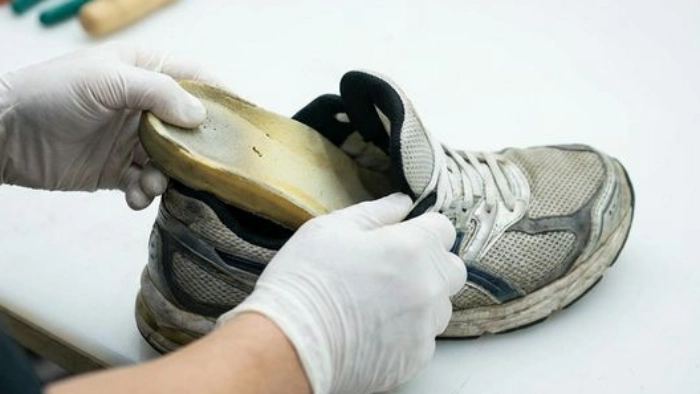 スニーカーのインソールを取り出している様子