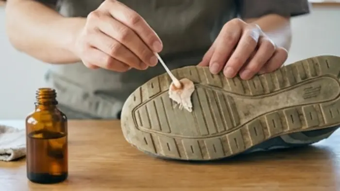 サラダ油を染み込ませたコットンで靴底のガムを拭き取る様子